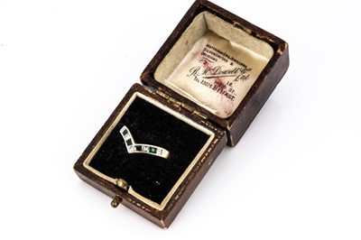 Lot 131 - An emerald and diamond 18ct gold wishbone dress ring