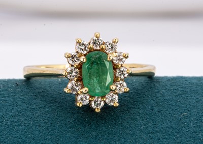 Lot 240 - An 18ct gold emerald and diamond cluster ring