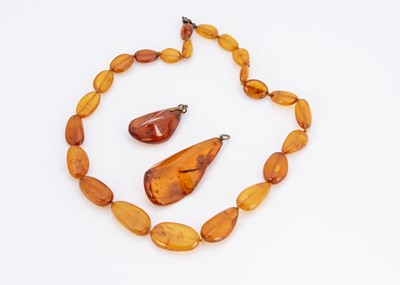 Lot 249 - Two Baltic amber pendants both having insect inclusions