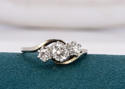 Lot 253 - A three stone diamond cross over ring