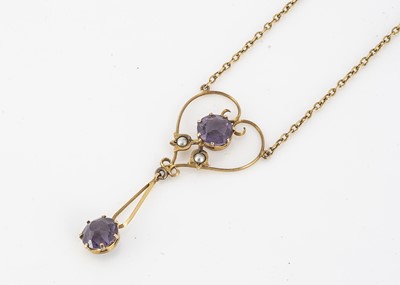 Lot 202 - An Edwardian 9ct gold amethyst and seed pearl openwork pendant and chain