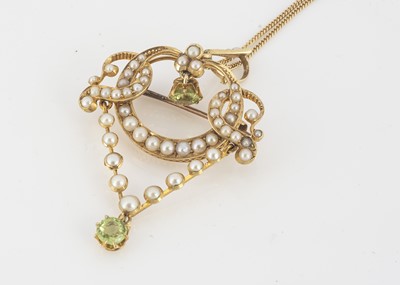 Lot 213 - An Edwardian gold, peridot and seed pearl openwork drop pendant
