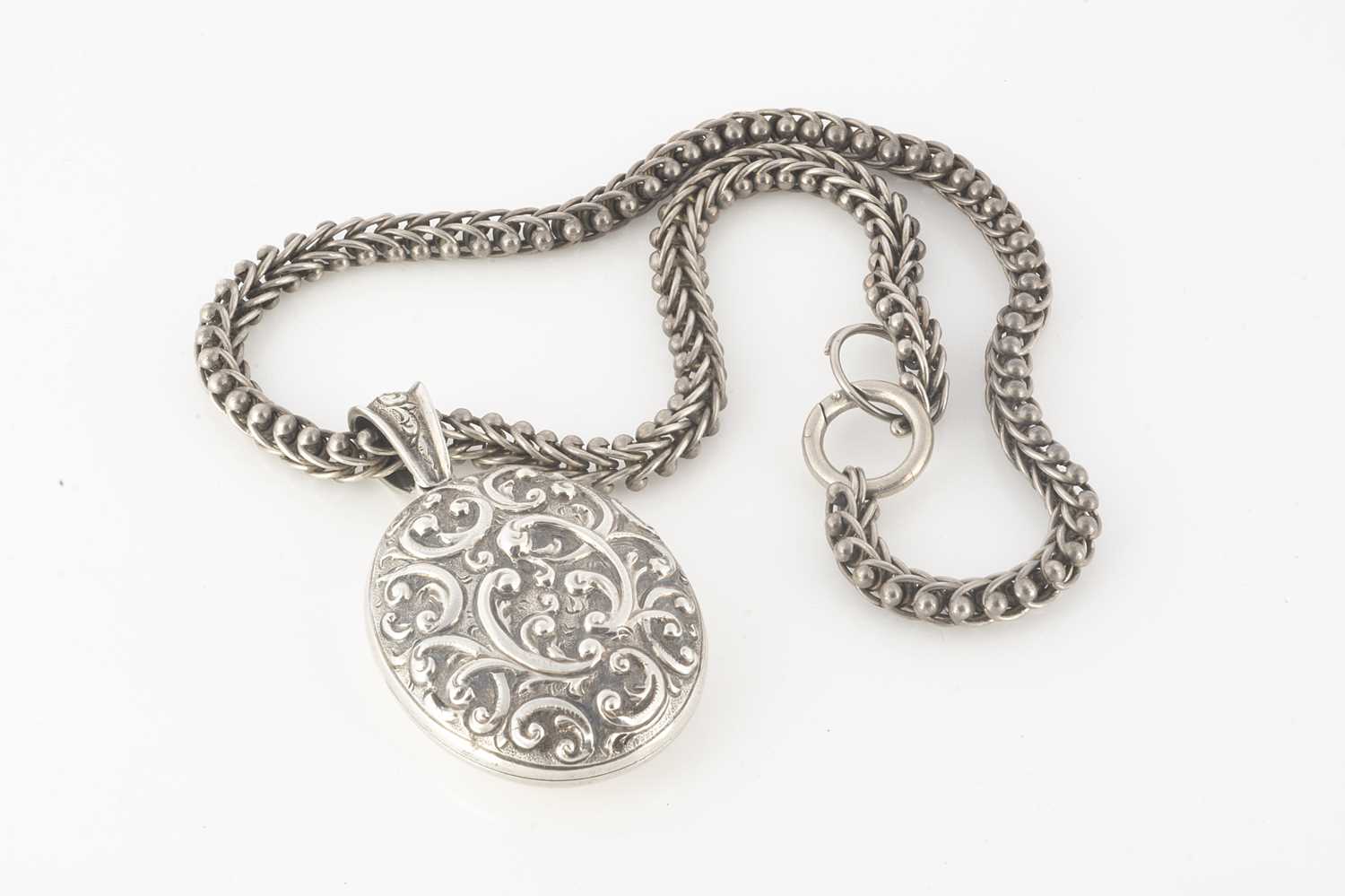 Lot 221 - A Victorian silver embossed oval locket