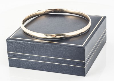 Lot 263 - A 9ct gold and metal core faceted arm bangle