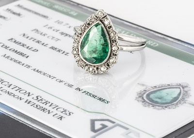 Lot 29 - A certificated emerald and diamond platinum pear shaped dress ring