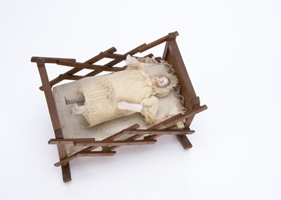 Lot 869 - An unusual late 19th century bisque headed baby in weighted rocking cradle