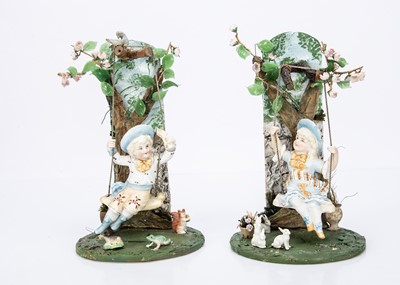 Lot 870 - A pair of German bisque children on tree swings