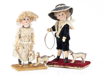 Lot 871 - Two German bisque headed dolls mounted with dogs