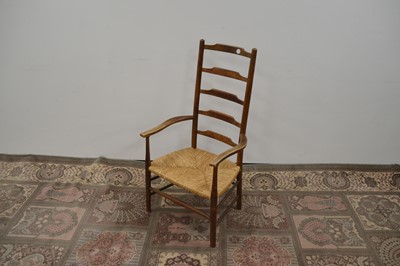 Lot 95 - An antique ladder-back chair with a rush seat