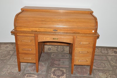 Lot 98 - An early 20th Century oak roll-topped or tambour partner's desk