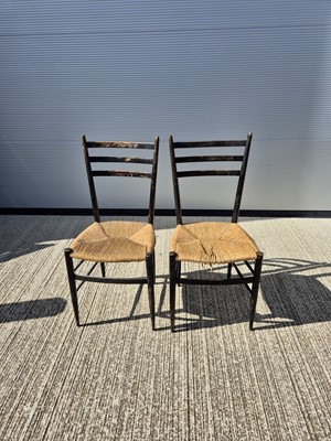 Lot 132 - A pair of mid 20th century ebonised rushed seated single chairs