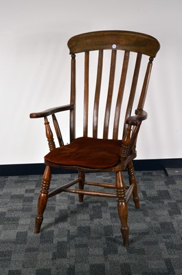 Lot 555 - An early 20th century elm and oak armchair