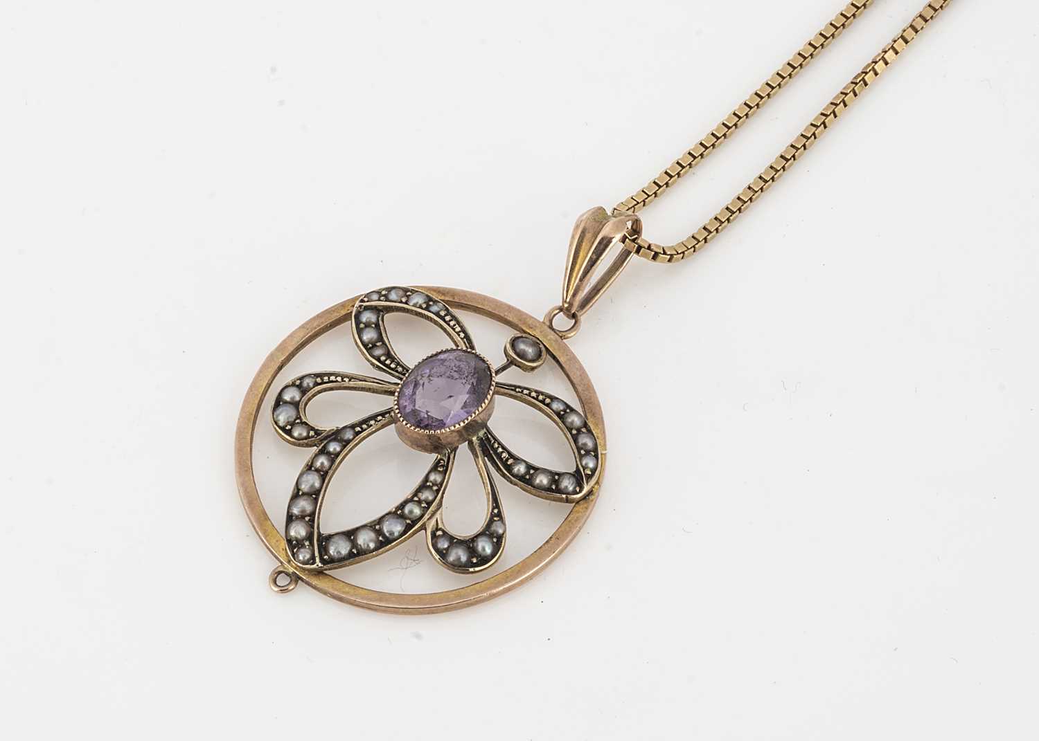 Lot 54 - An Edwardian 9ct gold amethyst and seed pearl drop openwork pendant