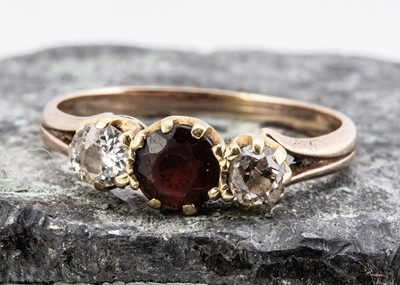 Lot 32 - An 18ct gold garnet and diamond three stone dress ring