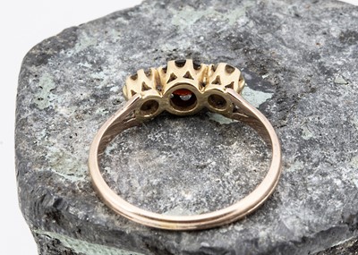 Lot 32 - An 18ct gold garnet and diamond three stone dress ring