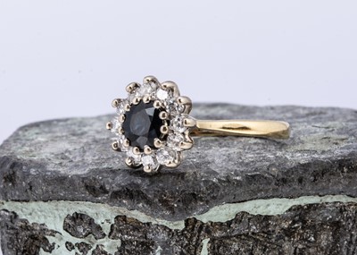 Lot 102 - An 18ct gold sapphire and diamond cluster ring