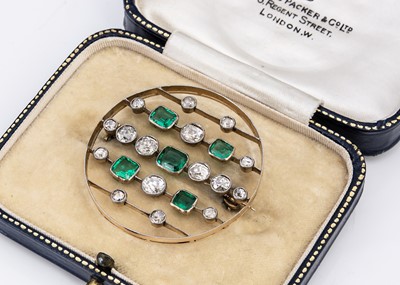 Lot 107 - An Art Deco emerald and diamond circular gold and platinum set brooch