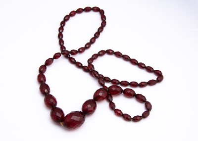 Lot 126 - A string of faceted 'cherry amber' beads