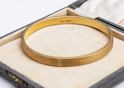 Lot 141 - An art deco 9ct gold flattened arm bangle with banded decoration