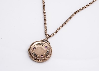 Lot 155 - An Edwardian circular 9ct gold front and back seed pearl and garnet locket