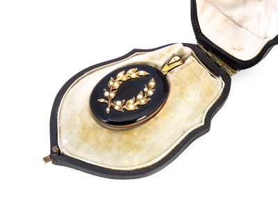 Lot 168 - A late 19th century black enamel and seed pearl oval locket