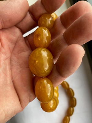 Lot 332 - A string of graduated pressed amber oval beads