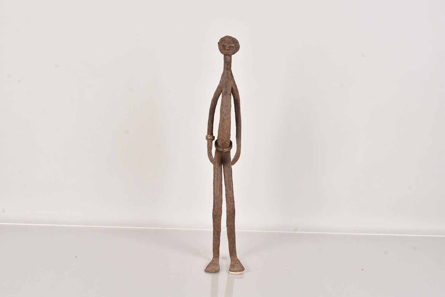 Lot 315 - An elongated metal figure of a male