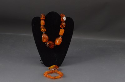 Lot 348 - Baltic Amber Boulder Necklace together with an amber broach and a rough amber bracelet