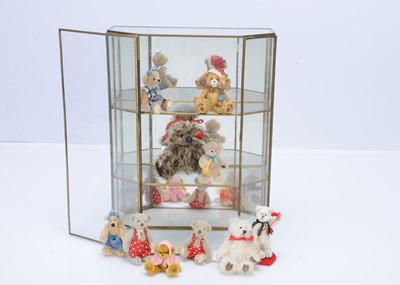 Lot 574 - A selection of collectable miniature teddy bears in a glass display cabinet