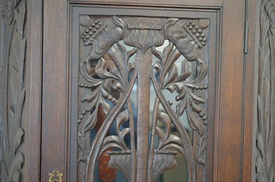 Lot 79 - An Arts and Crafts or Art Nouveau style carved oak corner cabinet