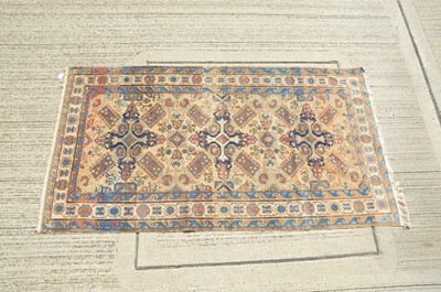 Lot 143 - A Middle Eastern wool rug woven with a design of three rosettes