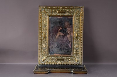 Lot 315 - An antique pressed brass wall miror with an integral shelf