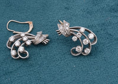 Lot 115 - A pair of continental white metal and diamond set scroll earrings