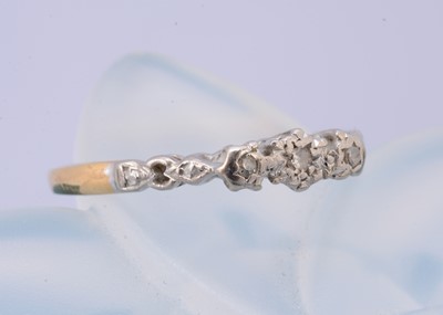 Lot 180 - An 18ct gold and three stone platinum diamond dress ring