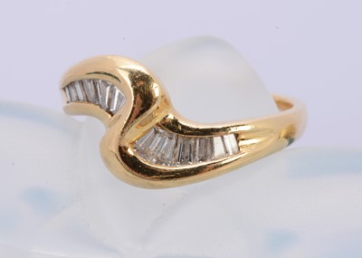 Lot 246 - An 18ct yellow gold and baguette diamond cut wave ring