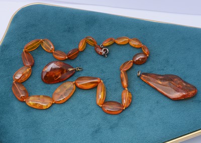 Lot 250 - Two Baltic amber pendants both having insect inclusions