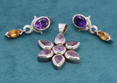 Lot 322 - An amethyst and silver set floral drop pendant