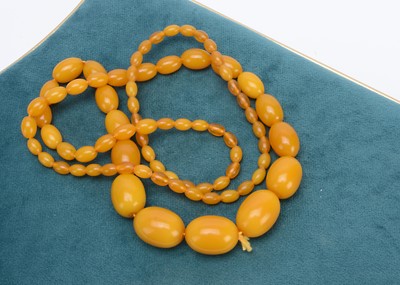 Lot 390 - A string of graduated oval amber beads