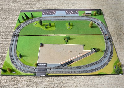 Lot 591 - An 00 Gauge 5' x 4' Model Railway layout with Hornby track Stations other Buildings and various scenic Accessories some unused (qty)