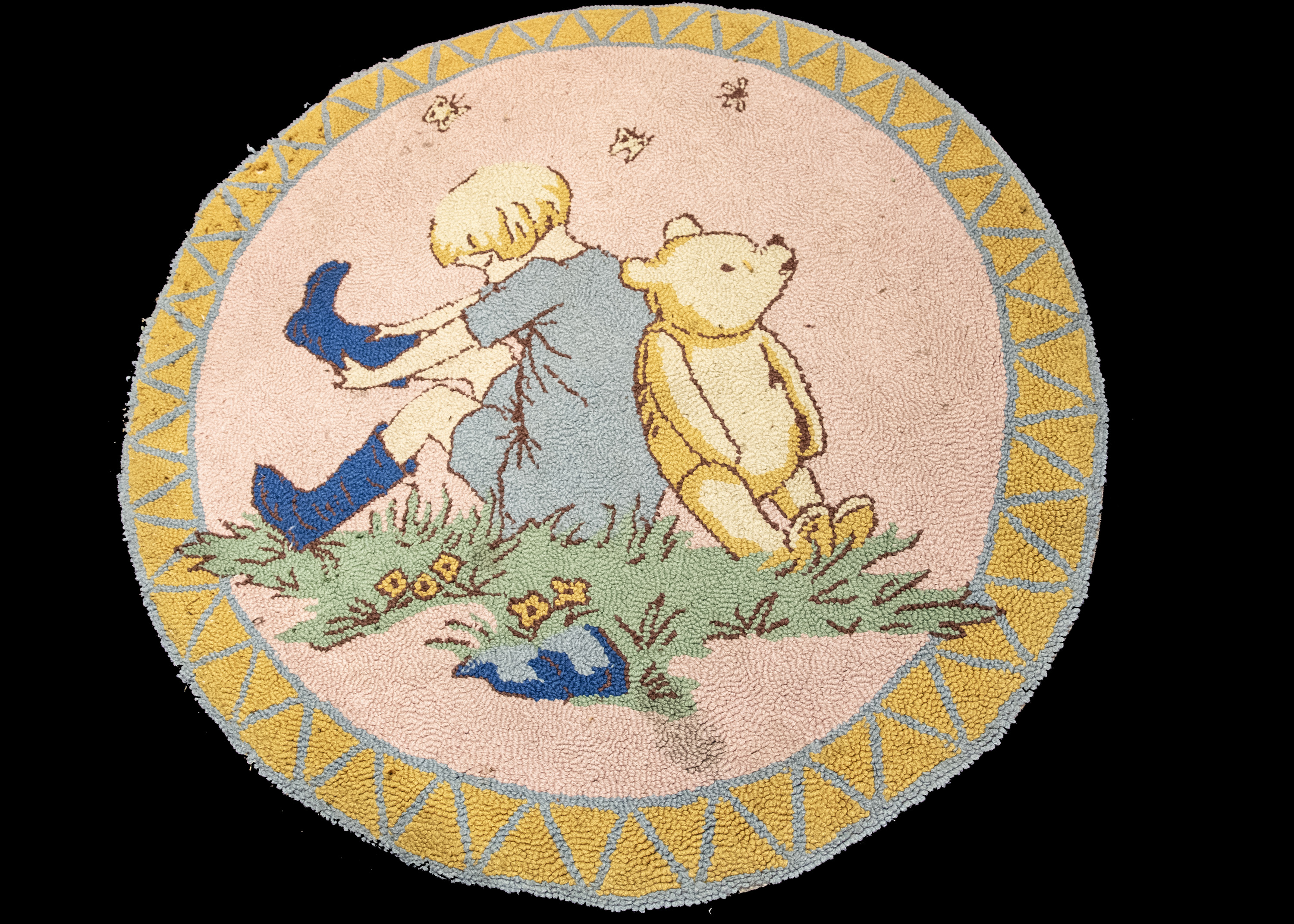 A circular Winnie the Pooh and Christopher Robin rug