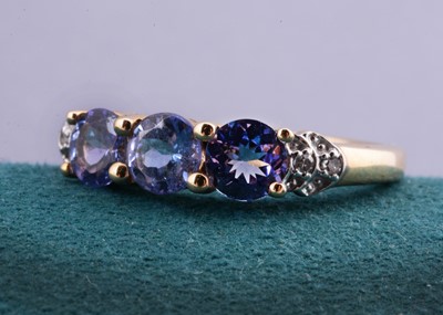 Lot 22 - A 9ct gold three stone tanzanite and diamond set dress ring