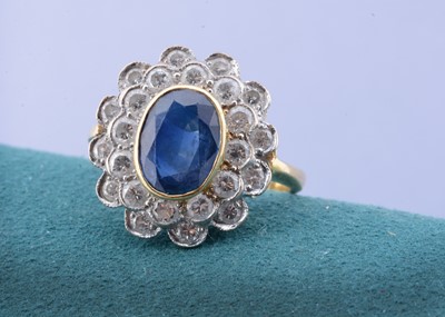 Lot 79 - A sapphire and diamond cluster ring in 18ct white and yellow gold