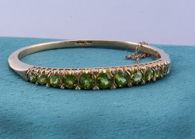 Lot 114 - A 9ct gold peridot and diamond hinged bangle