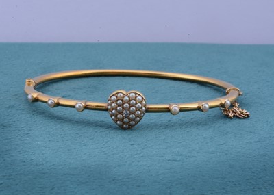 Lot 135 - An Edwardian seed pearl and diamond hinged bangle