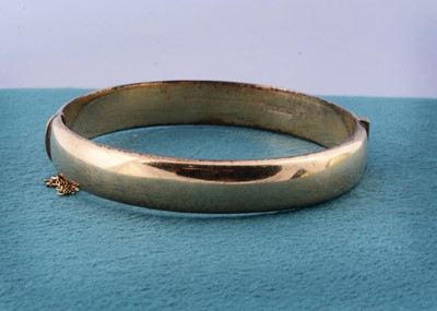 Lot 180 - A 9ct gold hinged bangle