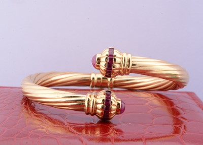 Lot 200 - A continental yellow metal ruby set hinged bangle