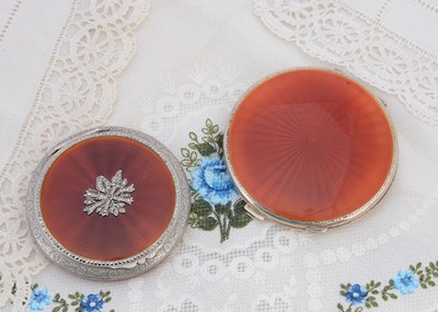 Lot 454 - Two circular silver compacts both with burnt orange guilloche enamel