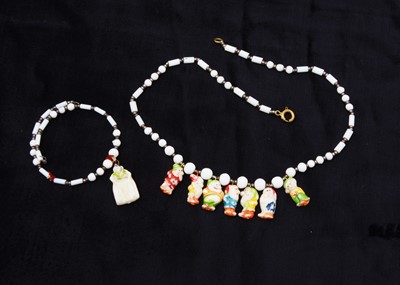 Lot 305 - Walt Disney Snow White and the Seven Dwarves milk glass necklace and braclet, circa 1938