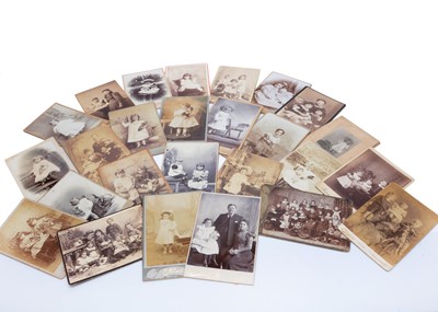 Lot 1015 - Twenty-seven 19th century photographic Cabinet Cards featuring children with dolls and toys