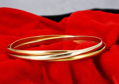 Lot 202 - A French 750 marked three colour and three ringed bangle